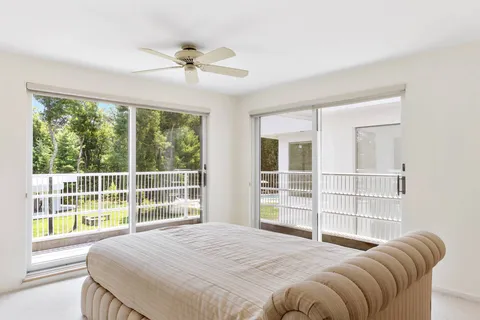 a bedroom with a bed and a large window