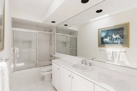 a bathroom with a granite countertop sink a toilet a shower and a mirror