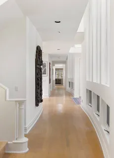 a view of a hallway with furniture and a window