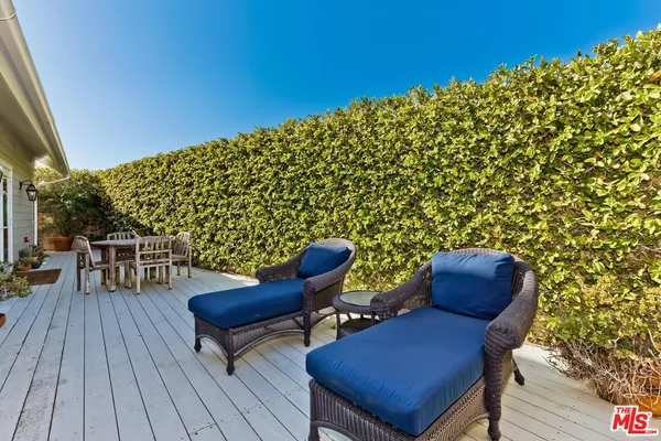 a balcony with wooden floor and outdoor seating