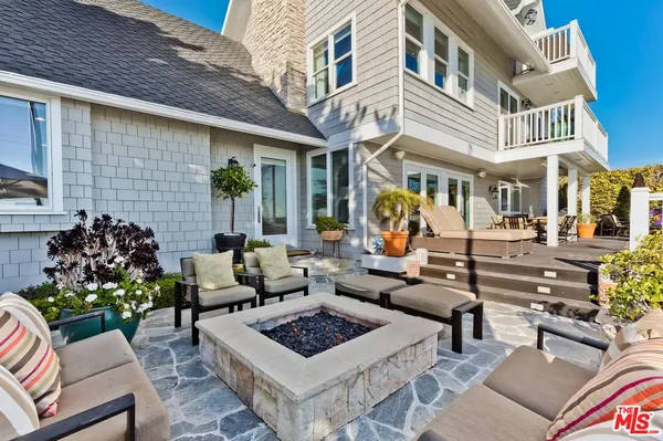 a view of a patio with couches table and chairs with potted plants