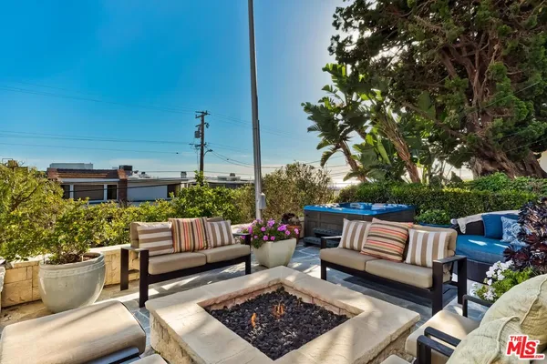 a view of a patio with table and chairs potted plants and a palm tree