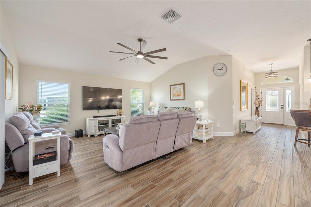 595 Randall Road The Villages, FL 32163 - Photo 12 of 42 a living room with furniture a flat screen tv and a fireplace