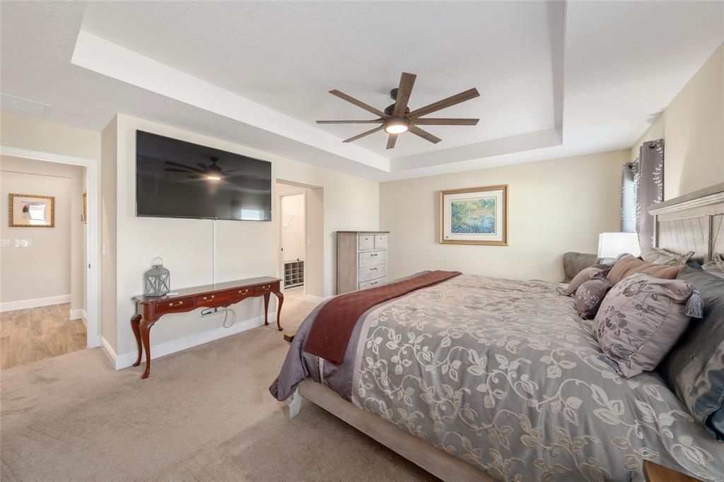 595 Randall Road The Villages, FL 32163 - Photo 18 of 42 a bedroom with a bed a flat screen tv and couches