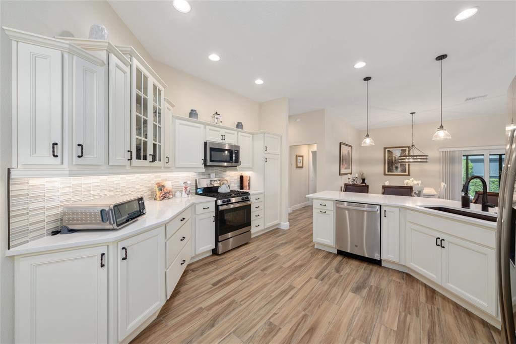 595 Randall Road The Villages, FL 32163 - Photo 6 of 42 a kitchen with white cabinets and appliances