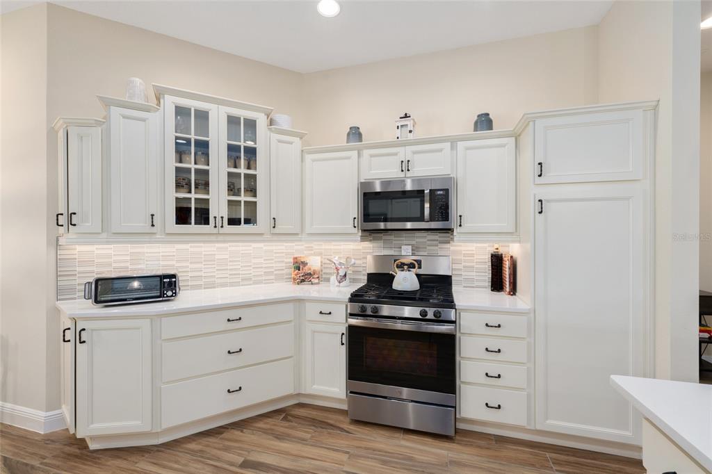 595 Randall Road The Villages, FL 32163 - Photo 7 of 42 a kitchen with stainless steel appliances a stove microwave and cabinets