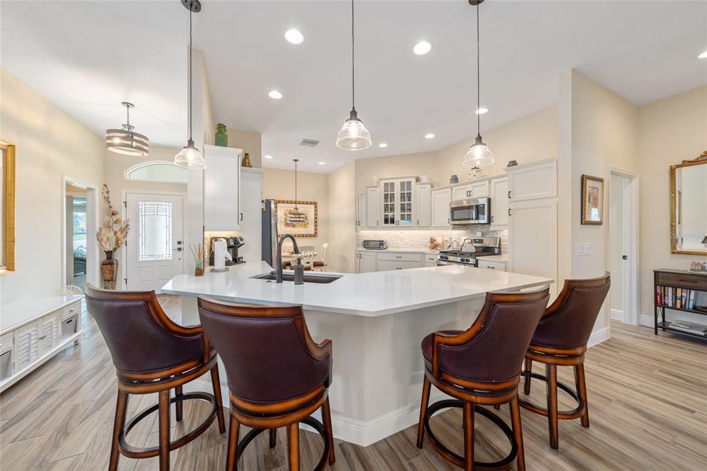 595 Randall Road The Villages, FL 32163 - Photo 9 of 42 a dining room with stainless steel appliances kitchen island a table and chairs