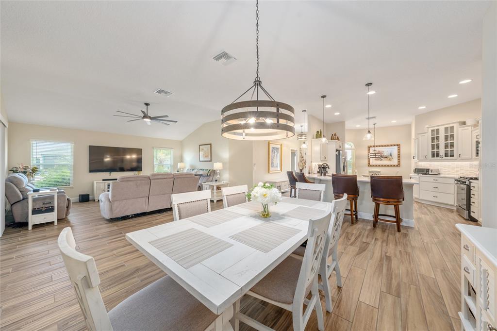 595 Randall Road The Villages, FL 32163 - Photo 10 of 42 a view of a dining room and livingroom with furniture wooden floor a chandelier
