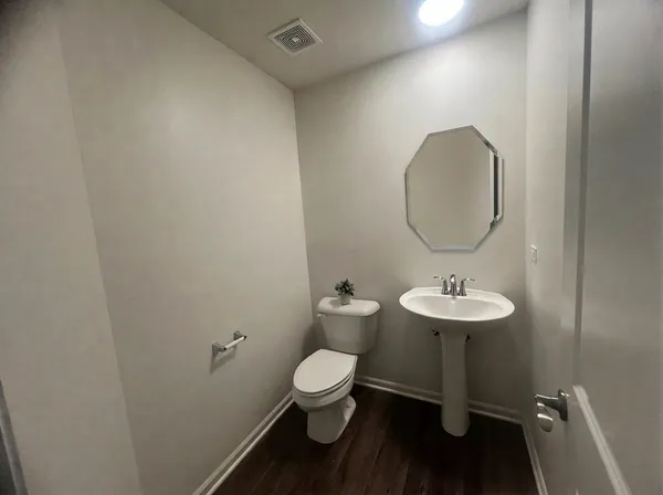 a bathroom with a toilet a sink and mirror