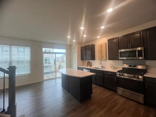 a kitchen with stainless steel appliances granite countertop a sink stove and wooden floor