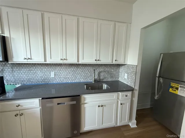 a kitchen with stainless steel appliances white cabinets and a sink