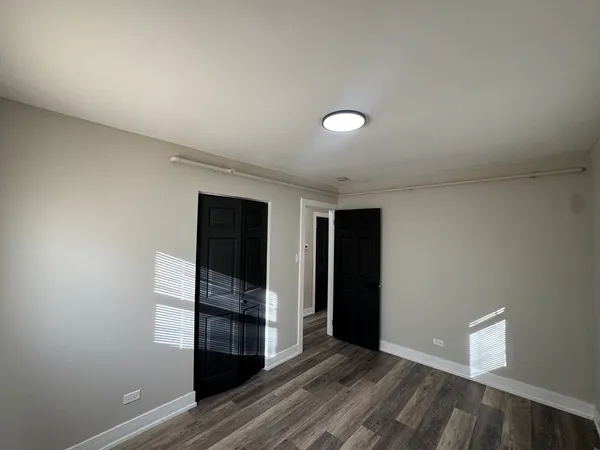 an empty room with closet and wooden floor