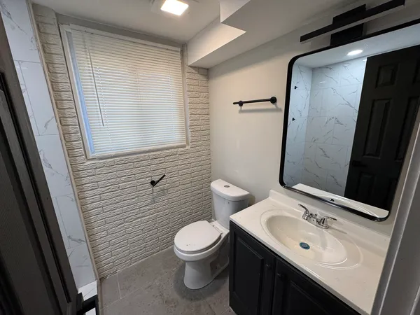 a bathroom with a sink a toilet and mirror