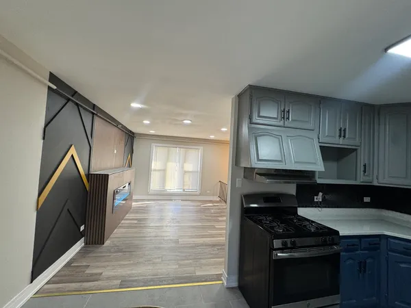 a kitchen with stainless steel appliances granite countertop a stove a sink and a microwave