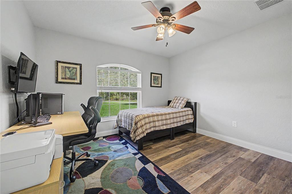 11213 Flock Avenue Weeki Wachee, FL 34613 - Photo 34 of 46 a bedroom with a bed bookshelf and a chair