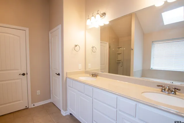 a spacious bathroom with a double vanity sink mirror and double