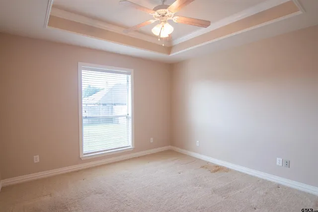 an empty room with a window and a fan