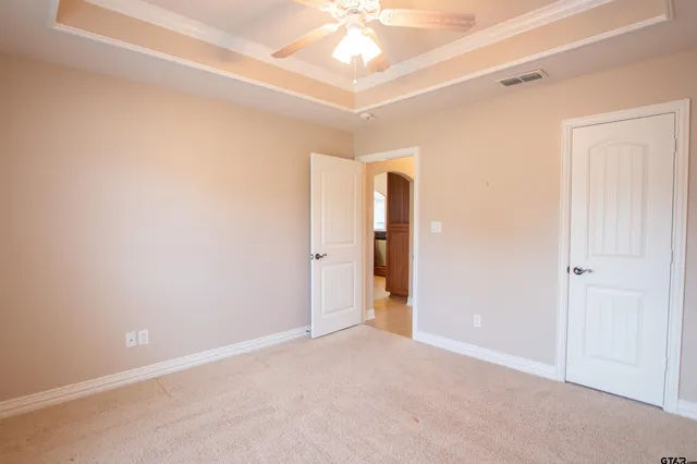 an empty room with a ceiling fan and window