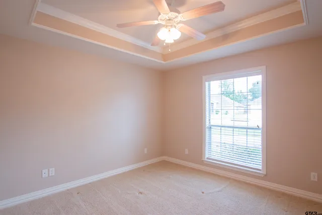 an empty room with a window and a fan