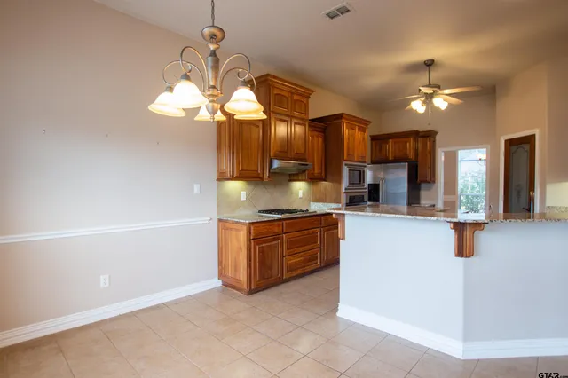 a kitchen with stainless steel appliances granite countertop a stove a sink and a refrigerator
