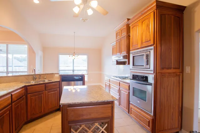 a kitchen with stainless steel appliances granite countertop a stove a sink and a refrigerator
