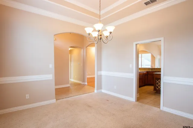 a view of a chandelier in big room with a chandelier