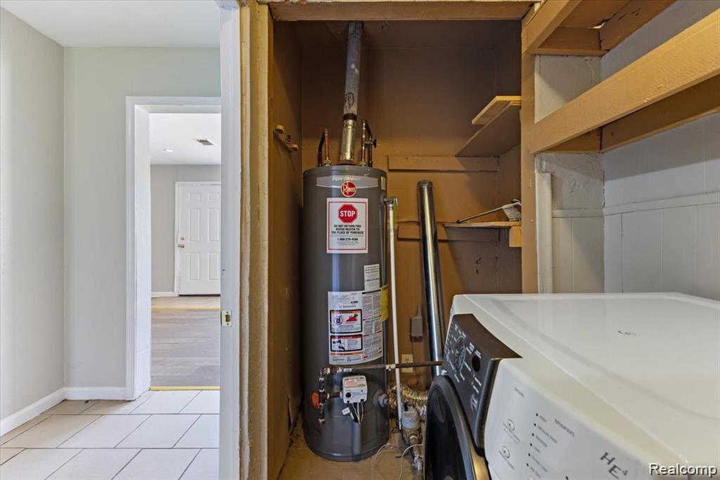 26076 Colgate Street Inkster, MI 48141 - Photo 12 of 24 Dedicated utility area featuring a water heater, built-in shelving, and a side-by-side washer and dryer setup
