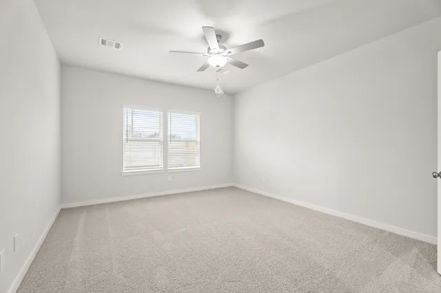 an empty room with a window and a ceiling fan