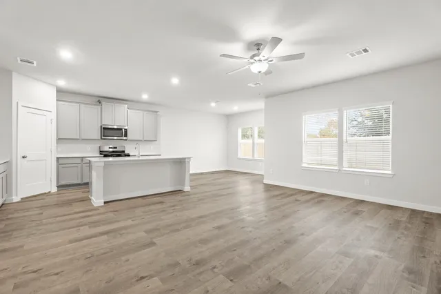 a view of kitchen with stove and white cabinets