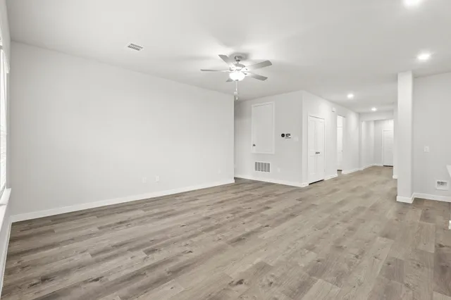 a view of an empty room with wooden floor