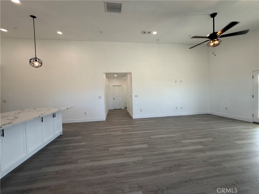 2115 Seville Place Pinon Hills, CA 92372 - Photo 21 of 31 a view of a room with wooden floor and white walls