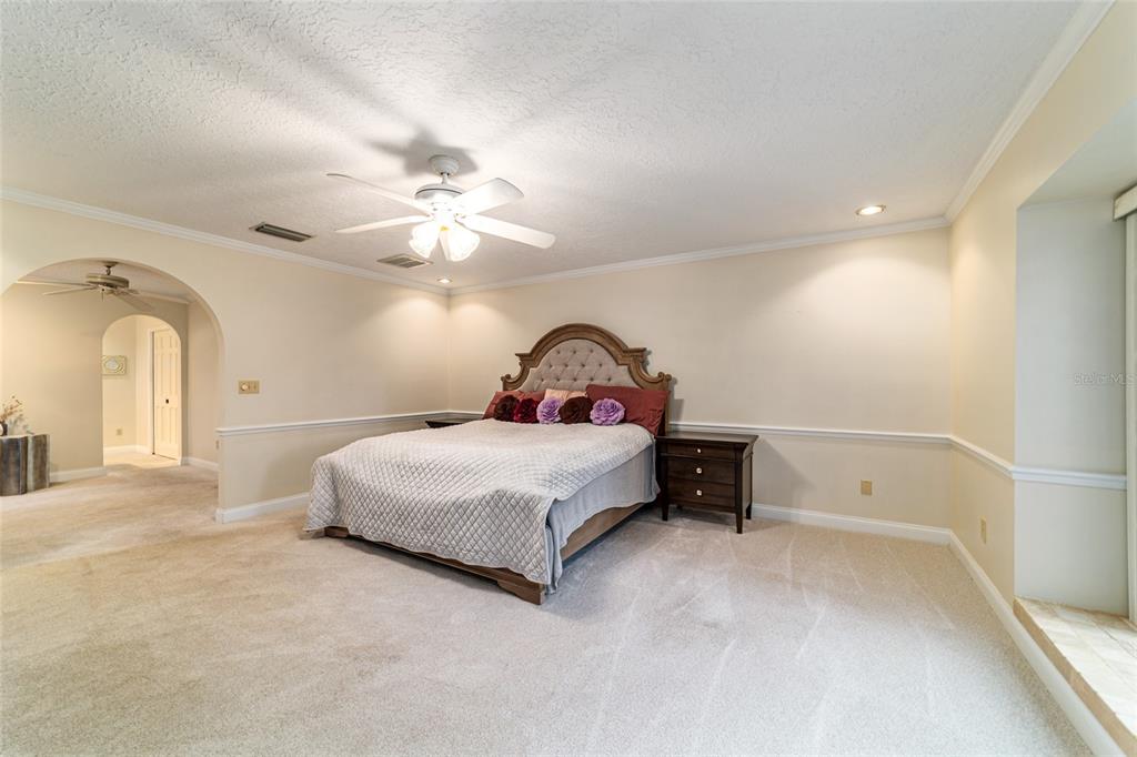 9080 Southwest 19th Avenue Road Ocala, FL 34476 - Photo 18 of 100 a bedroom with a bed and a chandelier