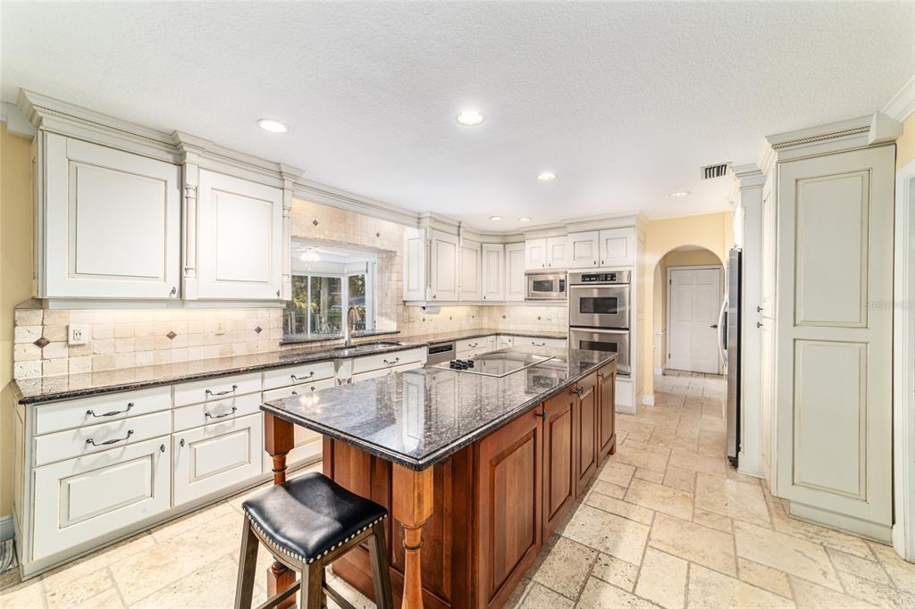 9080 Southwest 19th Avenue Road Ocala, FL 34476 - Photo 53 of 100 a kitchen with kitchen island granite countertop a sink and refrigerator