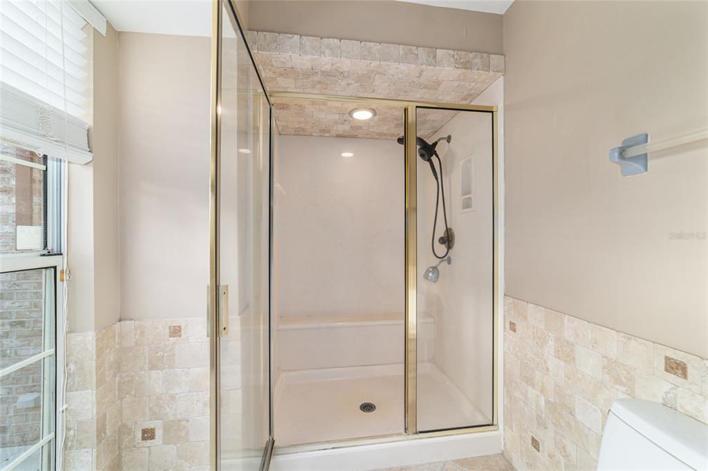 9080 Southwest 19th Avenue Road Ocala, FL 34476 - Photo 74 of 100 a bathroom with a glass shower door and a mirror
