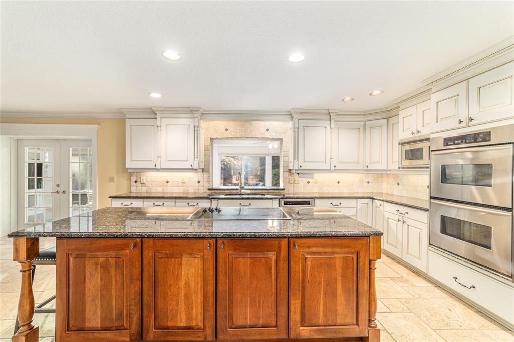 9080 Southwest 19th Avenue Road Ocala, FL 34476 - Photo 75 of 100 a kitchen with granite countertop stainless steel appliances and white cabinets