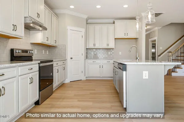 a large kitchen with stainless steel appliances granite countertop a stove a sink dishwasher and a refrigerator