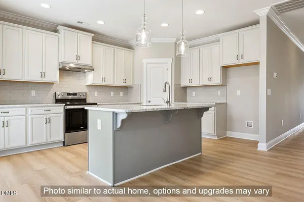 a kitchen with kitchen island granite countertop a sink cabinets and stainless steel appliances