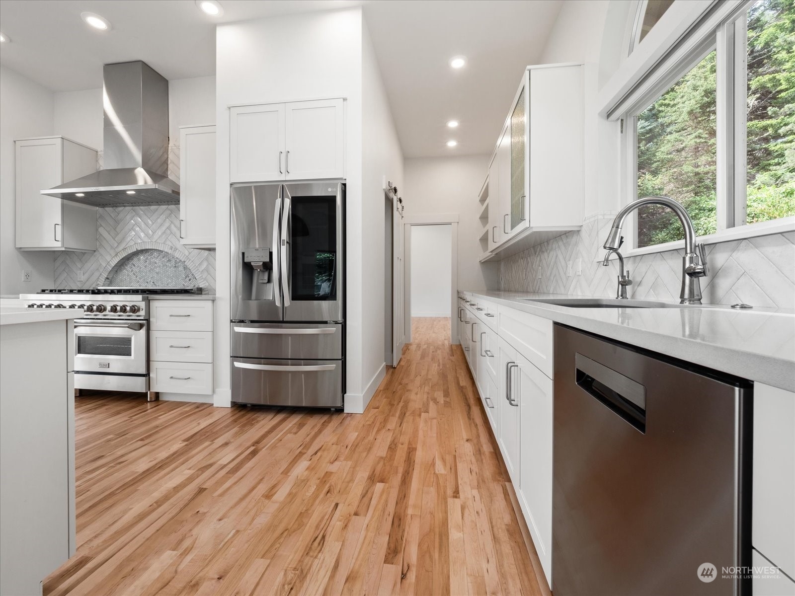 4191 Islander Way Anacortes, WA 98221 - Photo 4 of 40 a kitchen with stainless steel appliances granite countertop a sink a stove and a wooden floors