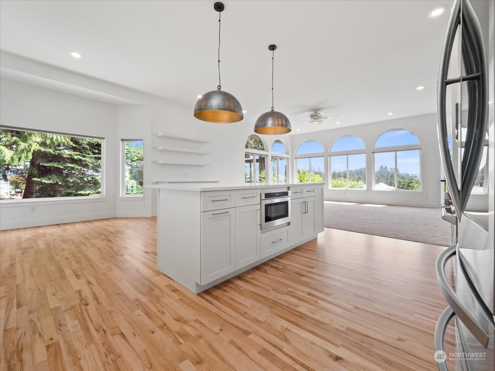 4191 Islander Way Anacortes, WA 98221 - Photo 6 of 40 a kitchen with stainless steel appliances granite countertop wooden floors sink and white cabinets