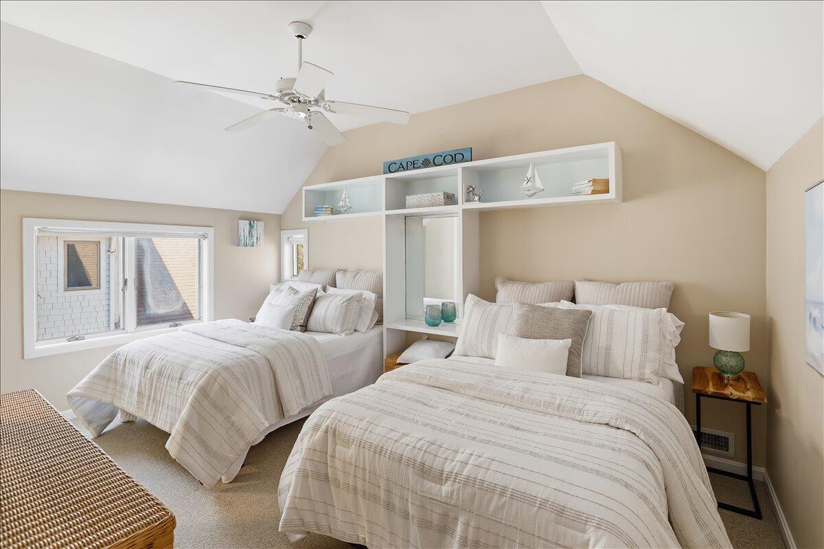 100 Mid-Iron Way, Unit 7027 Mashpee, MA 02649 - Photo 19 of 38 a bedroom with two beds and a chandelier