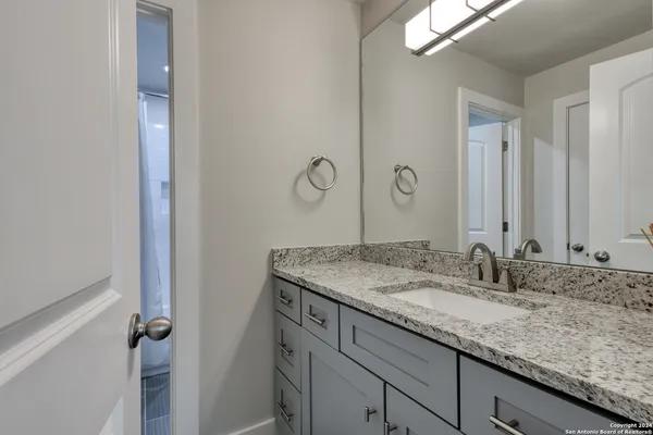a bathroom with a granite countertop sink and a mirror