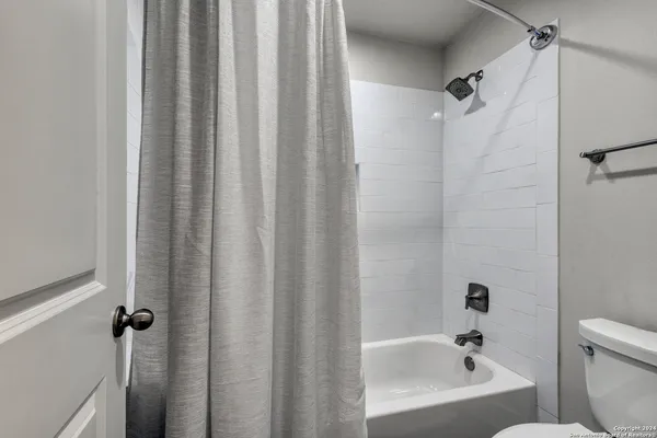 a bathroom with bathtub shower
