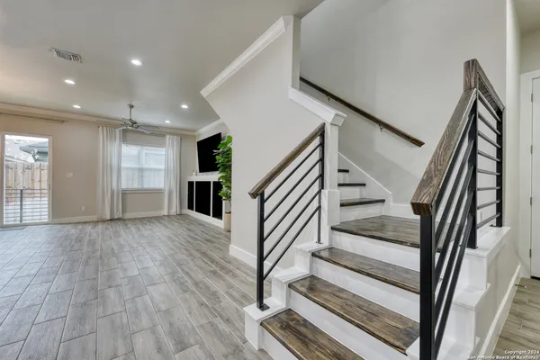 a view of staircase with wooden floor and front door