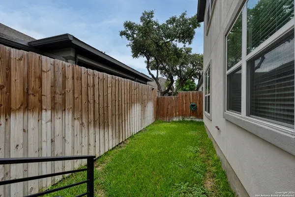 a view of a backyard with wooden fence