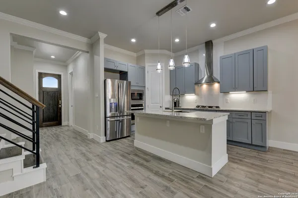 a kitchen with stainless steel appliances kitchen island granite countertop a refrigerator and a stove