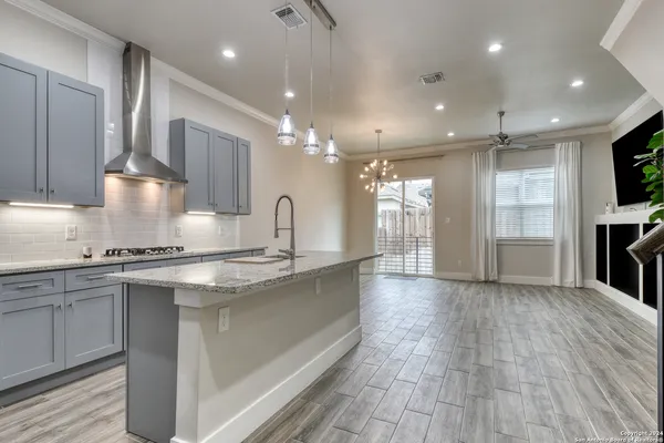 a large kitchen with stainless steel appliances a large counter top a stove and a refrigerator