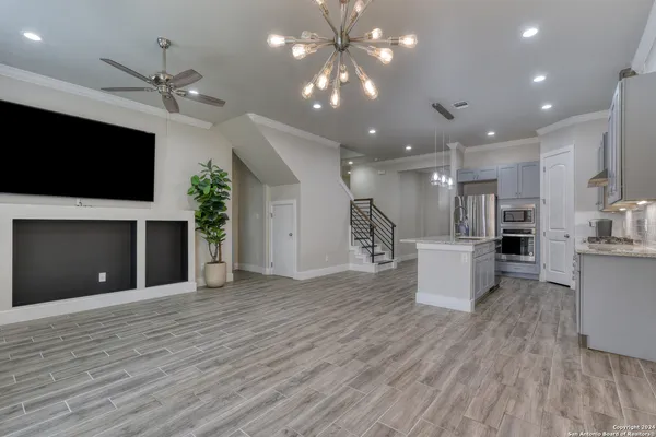 a view of a big room with wooden floor and a kitchen