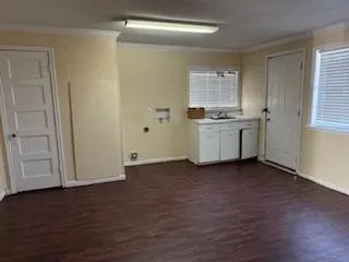 a view of an empty room with window and wooden floor
