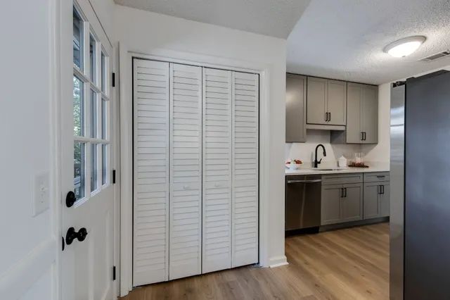 a kitchen with stainless steel appliances granite countertop a sink and cabinets with wooden floor