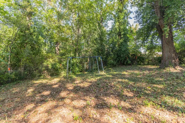 a big yard with lots of green space and house in the back